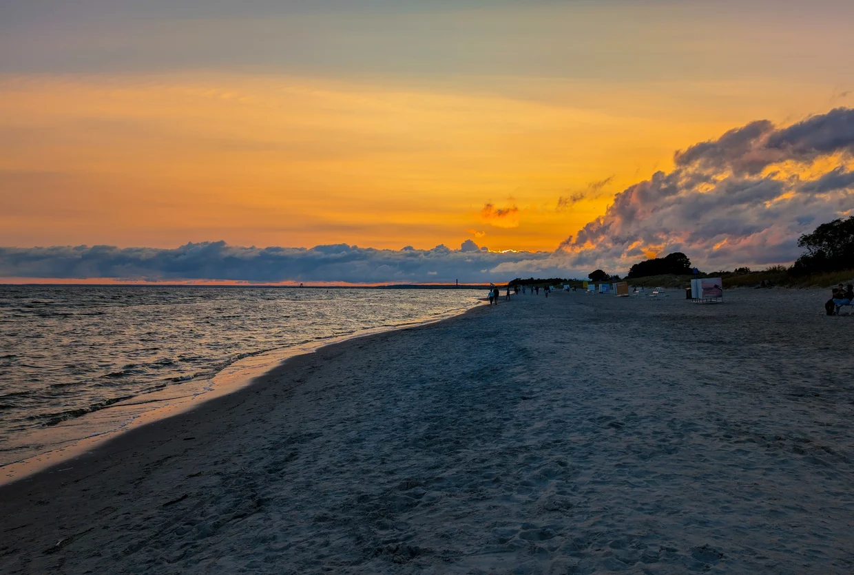 Orange sunset over Pärnu Beach with wide sand stretching into the distance