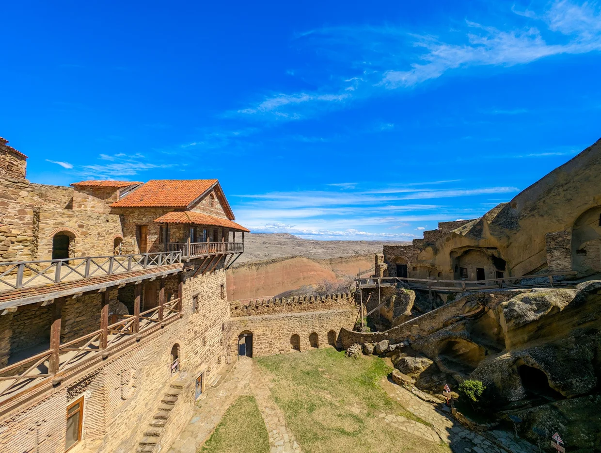 The monastery buildings with the vast arid valley stretching behind them