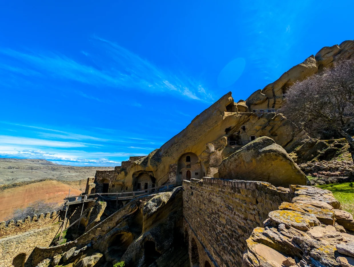Outer monastery wall with cave cells in the cliff above