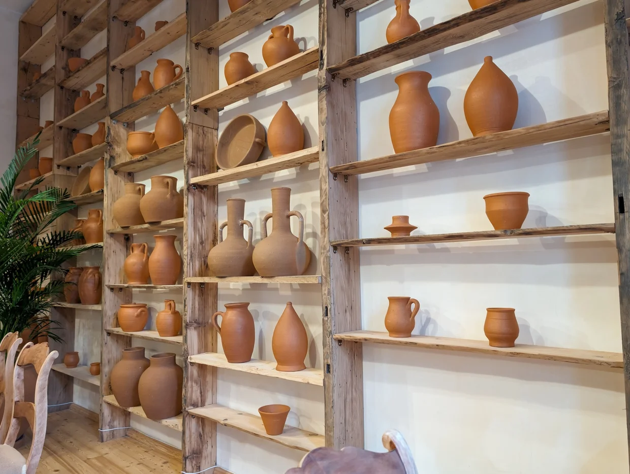 Clay wine vessels and pottery displayed on shelves at a Tbilisi wine shop