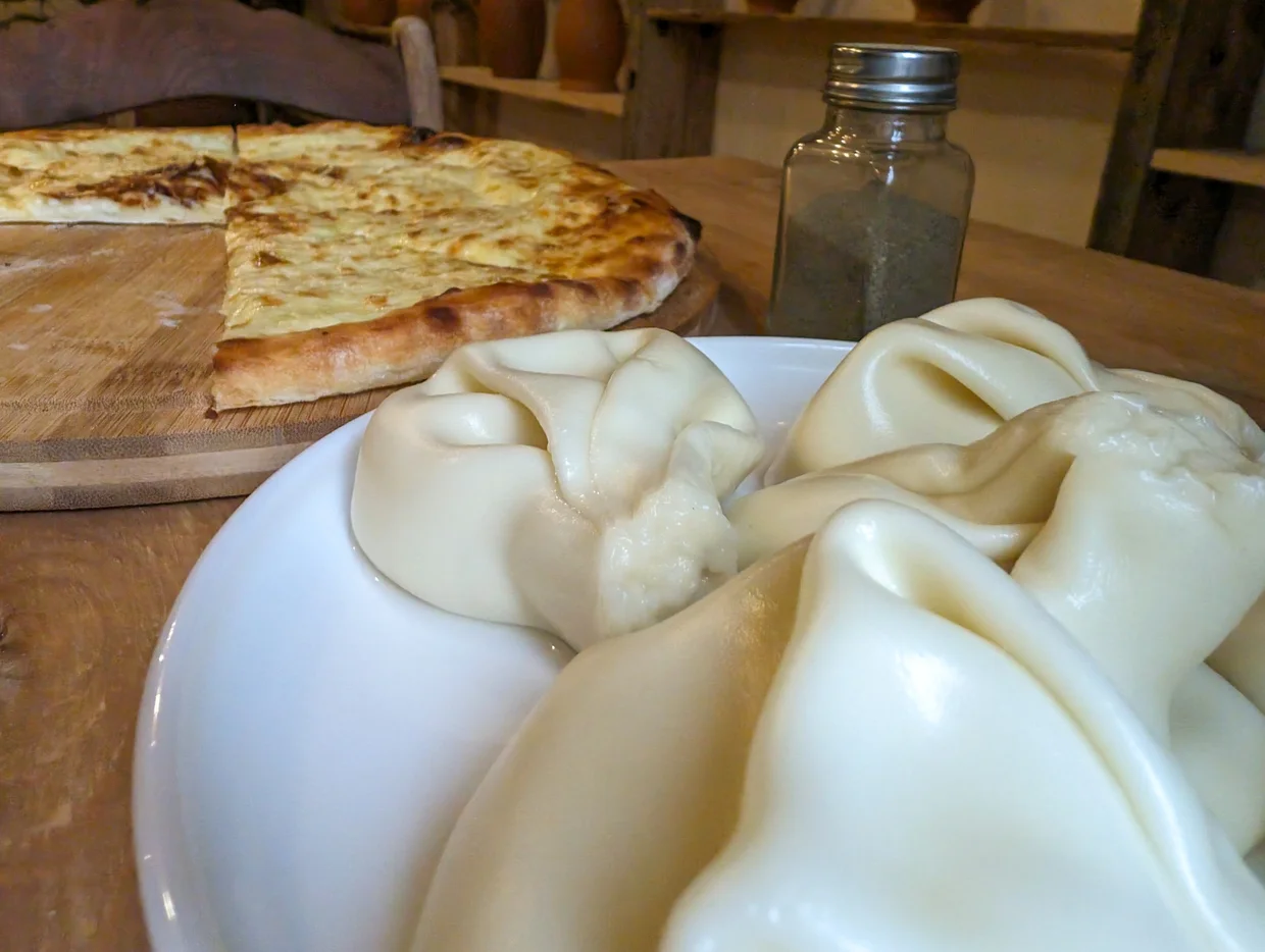 Khinkali dumplings and khachapuri bread at a Georgian restaurant table
