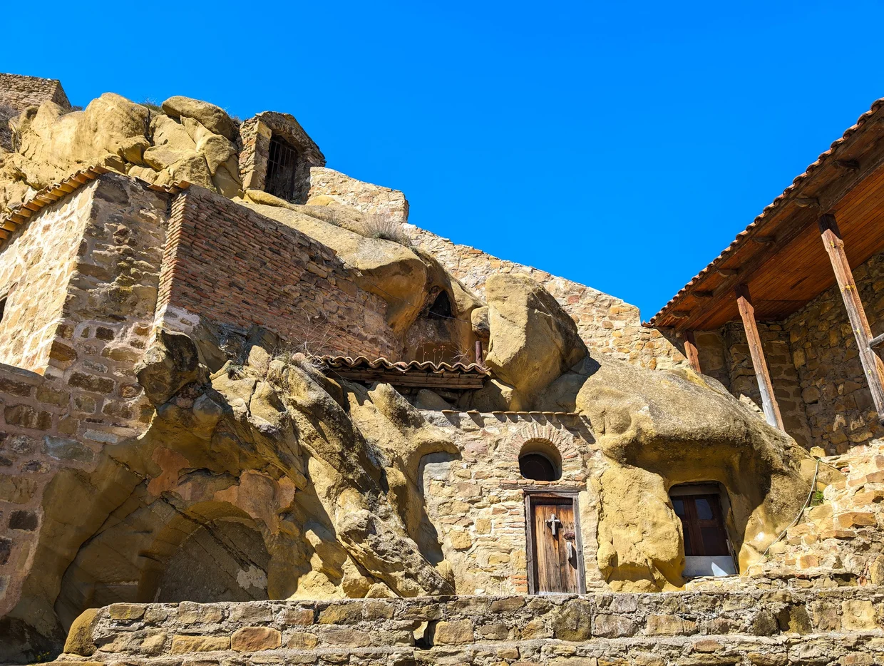 Cave cells in the rock with a small doorway and cross