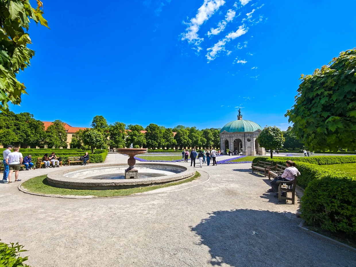 Round Hofgartenbrunnen fountain in the foreground with the Dianatempel behind