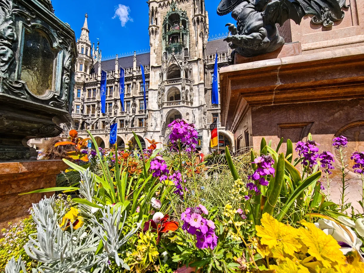 Marienplatz with Mariensäule, Neues Rathaus tower and a foreground of bright flowers