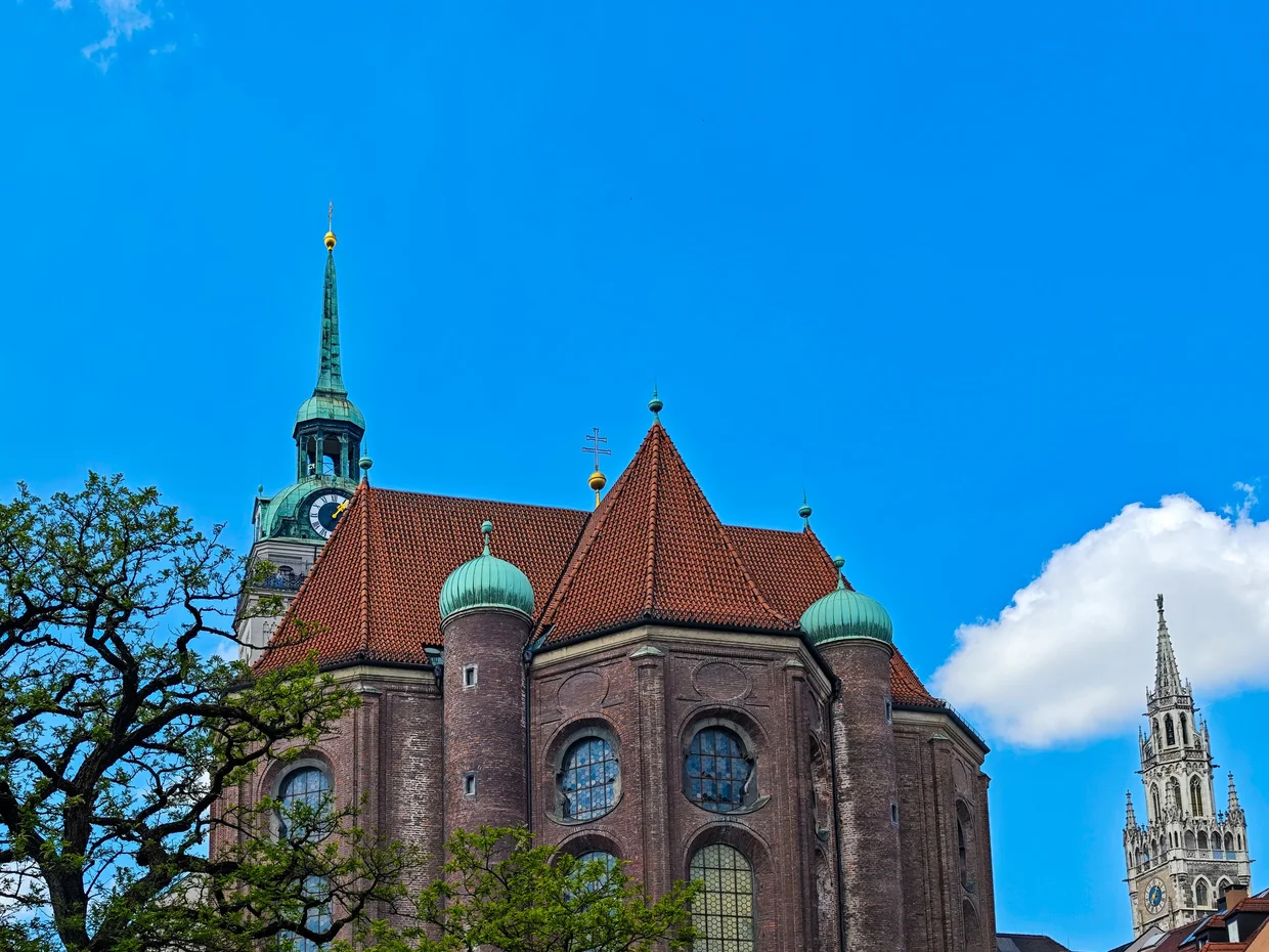 Brick gothic apse of Heilig-Geist-Kirche seen from Viktualienmarkt with the Neues Rathaus tower behind