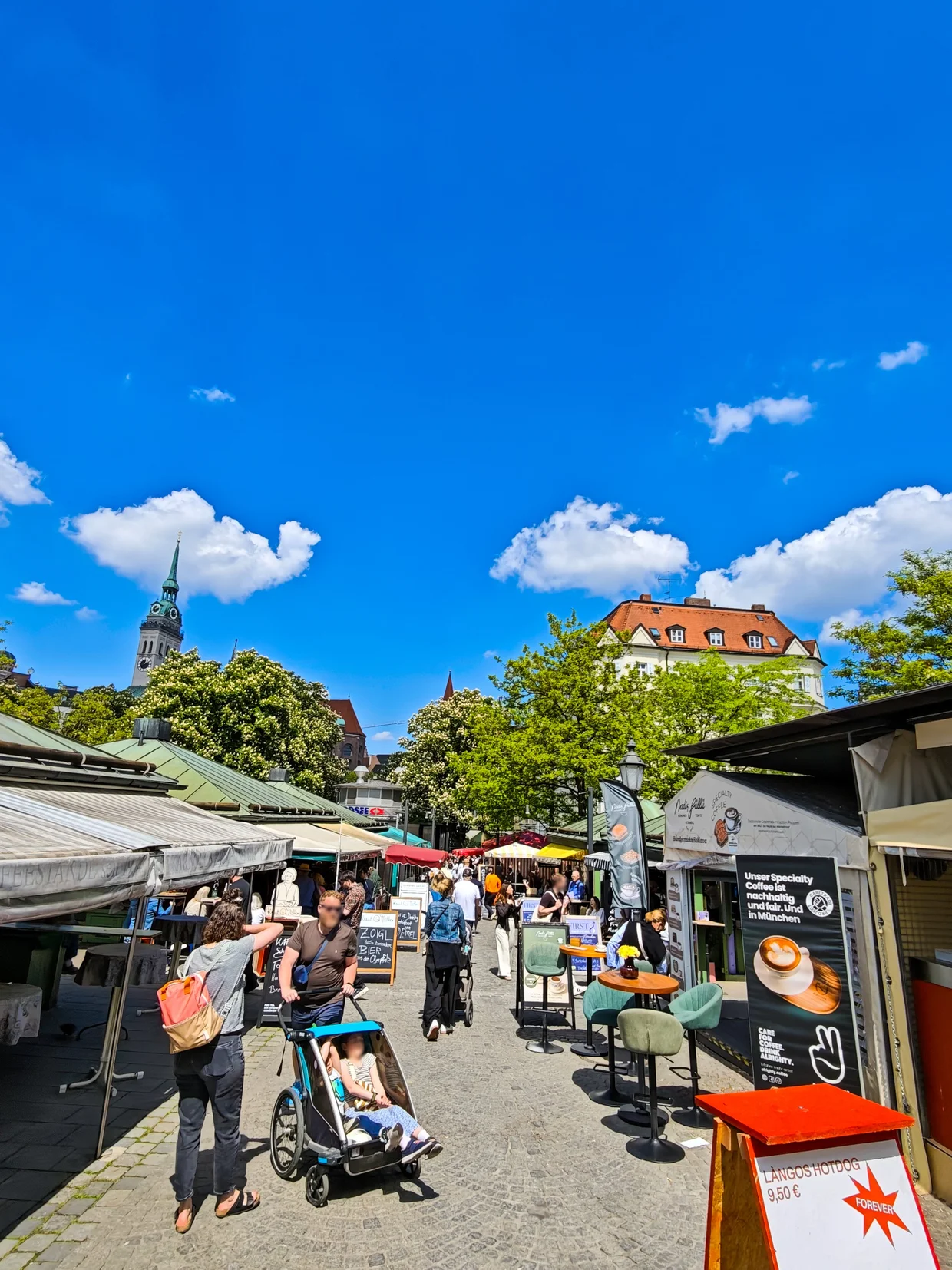 Viktualienmarkt with stalls and crowds, Alter Peter church tower in the background