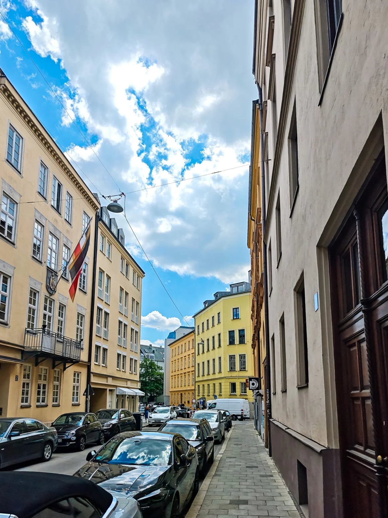 Quiet side street behind the Hofbräuhaus with parked cars and pastel facades