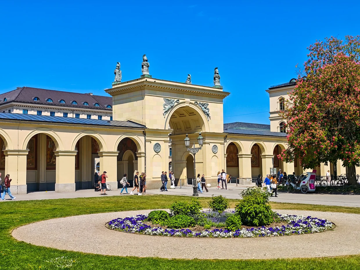 The Hofgartentor entry portico from inside the Hofgarten with a flowerbed in front