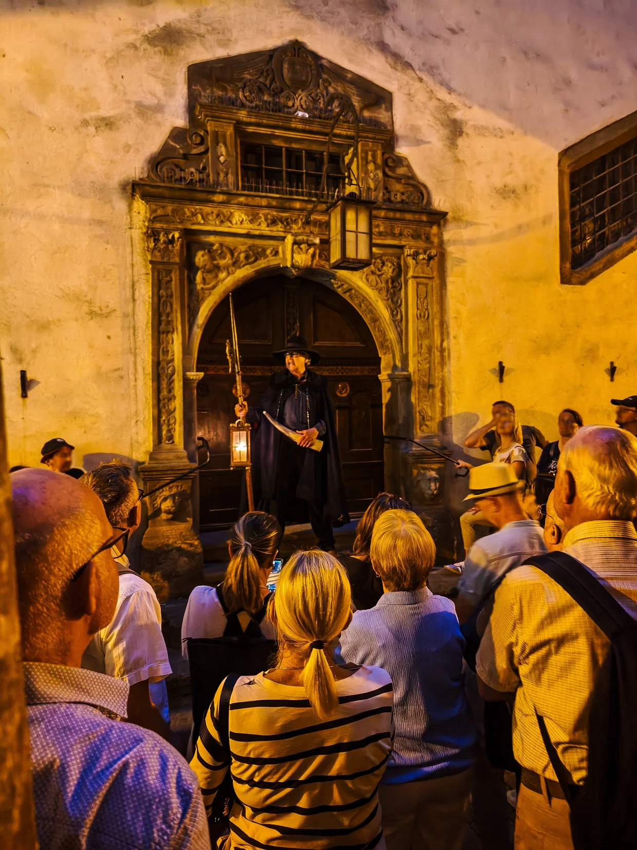 The night watchman with cape, lantern, and halberd at one of the tour's stops