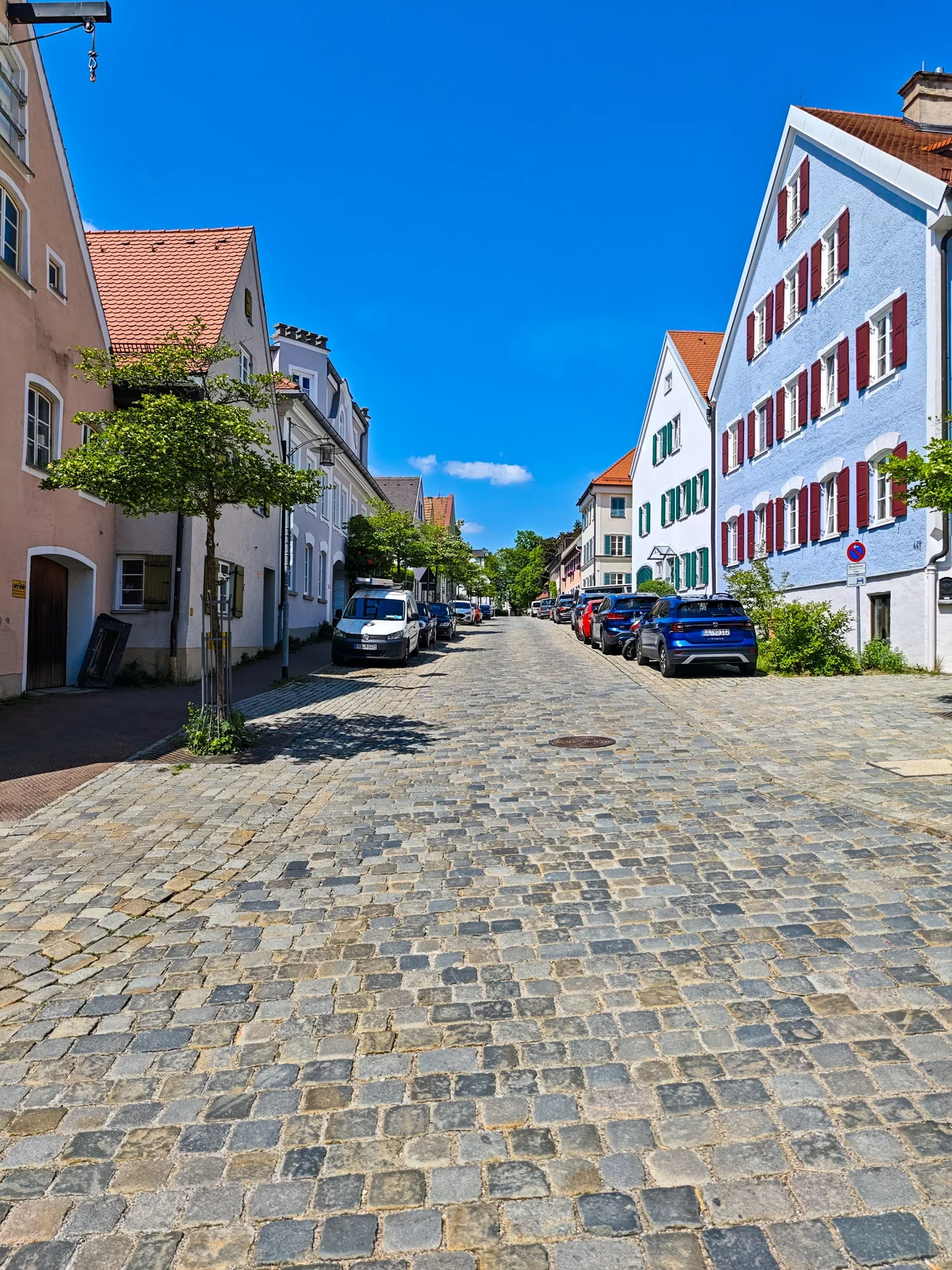 Hilly cobbled street with blue building