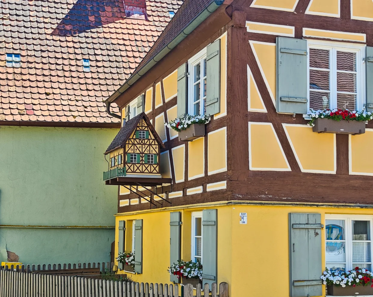 Mustard-yellow half-timber with red brick gable