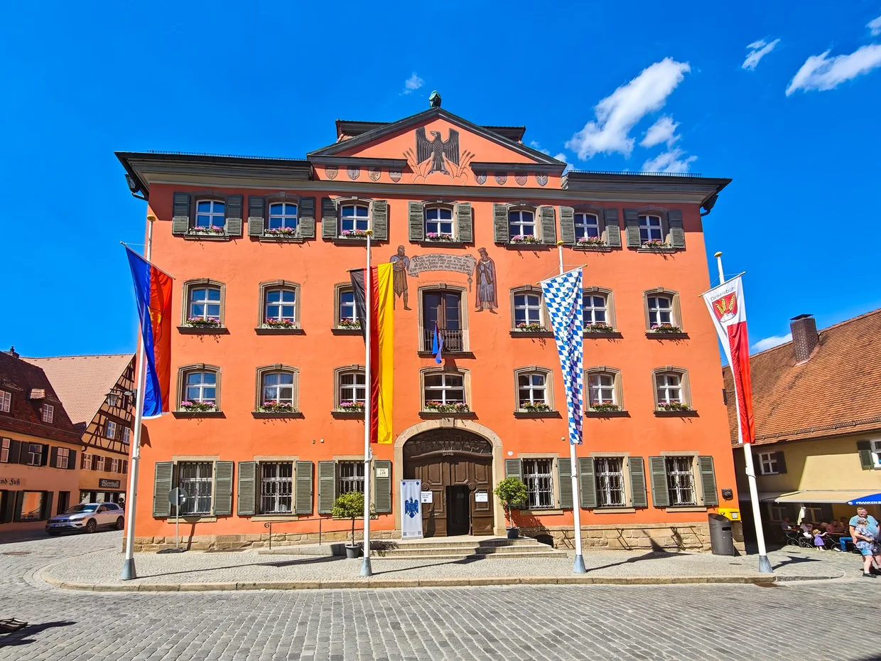 The orange Rathaus on Dinkelsbuhl's market square under a clear blue sky
