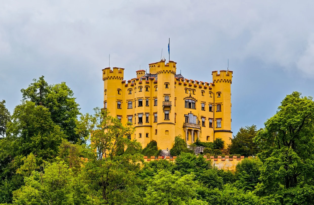 The yellow Schloss Hohenschwangau on its hill