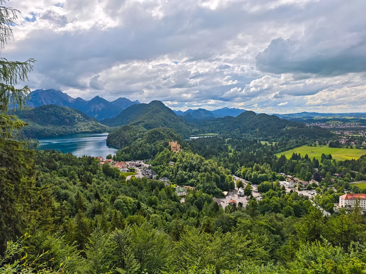 A grand overlook taking in Hohenschwangau, the Alpsee and the mountains
