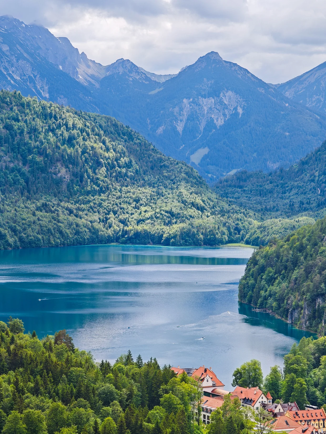 A telephoto across the Alpsee to a lakeside hotel and the peaks