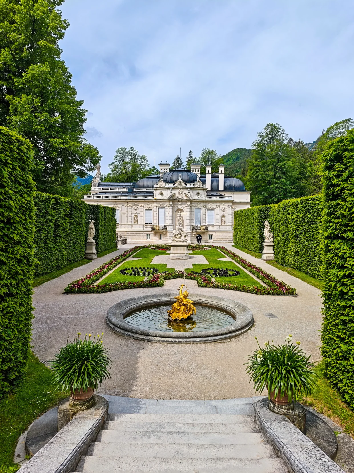The west facade of Linderhof with its trellis garden and gilded fountain