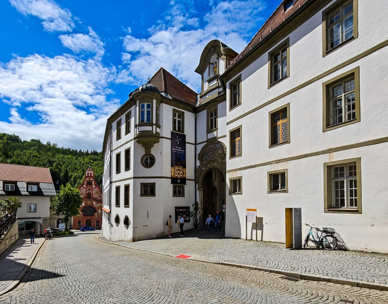 A wide cobbled gateway with a red church facade to the left