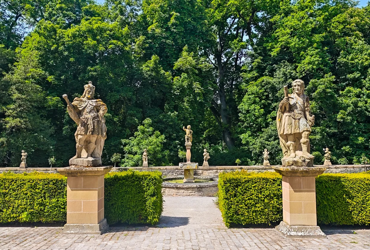 Twin baroque statues on plinths in the garden