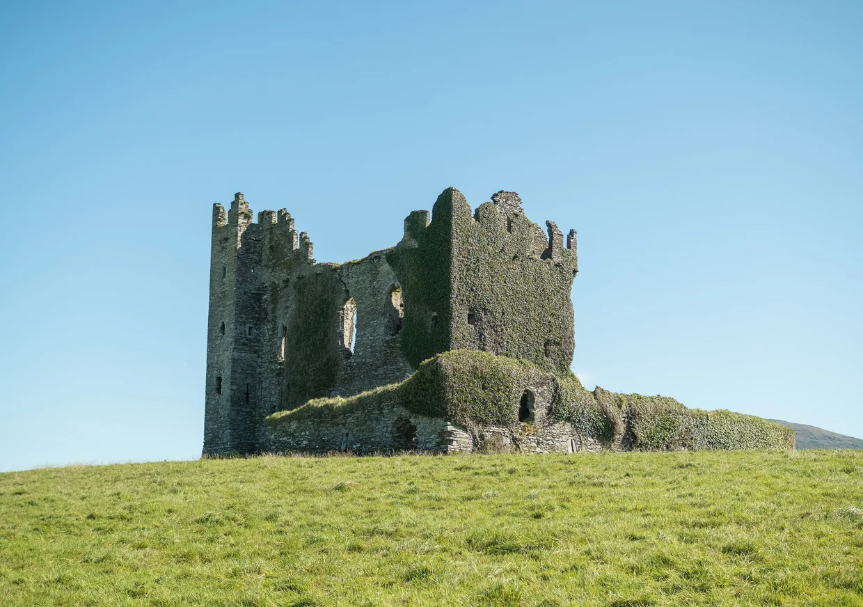 Ivy-covered Ballycarbery Castle ruin on a green hilltop near Cahersiveen