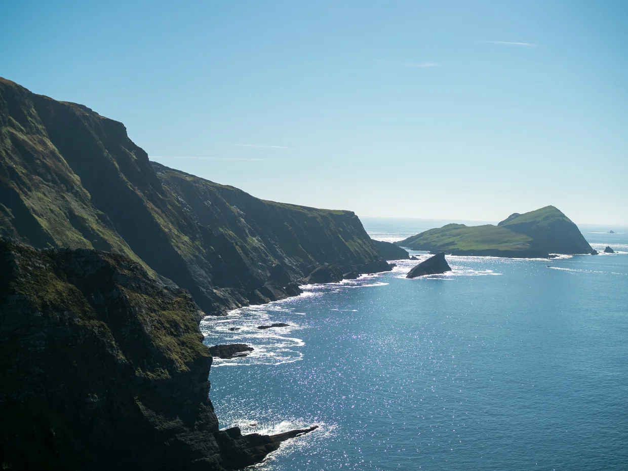 Steep dark coastal cliffs on the Iveragh Peninsula above a sparkling Atlantic