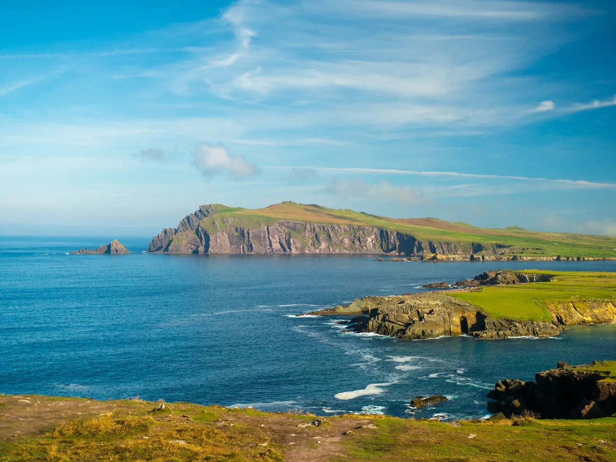 A green headland and small rocky islands off the Dingle Peninsula