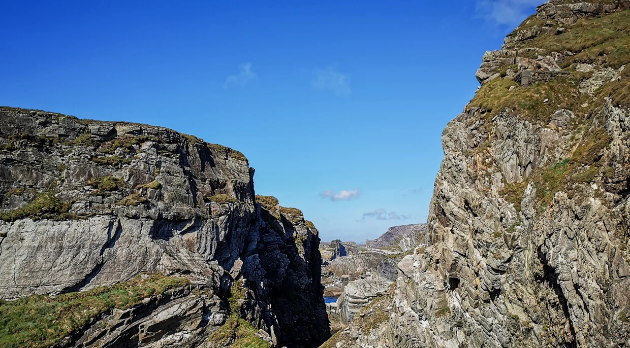 A narrow rocky cleft between layered cliff faces at Mizen Head