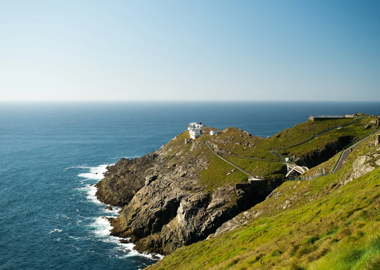 Mizen Head signal station and lighthouse on the rocky headland above a blue sea