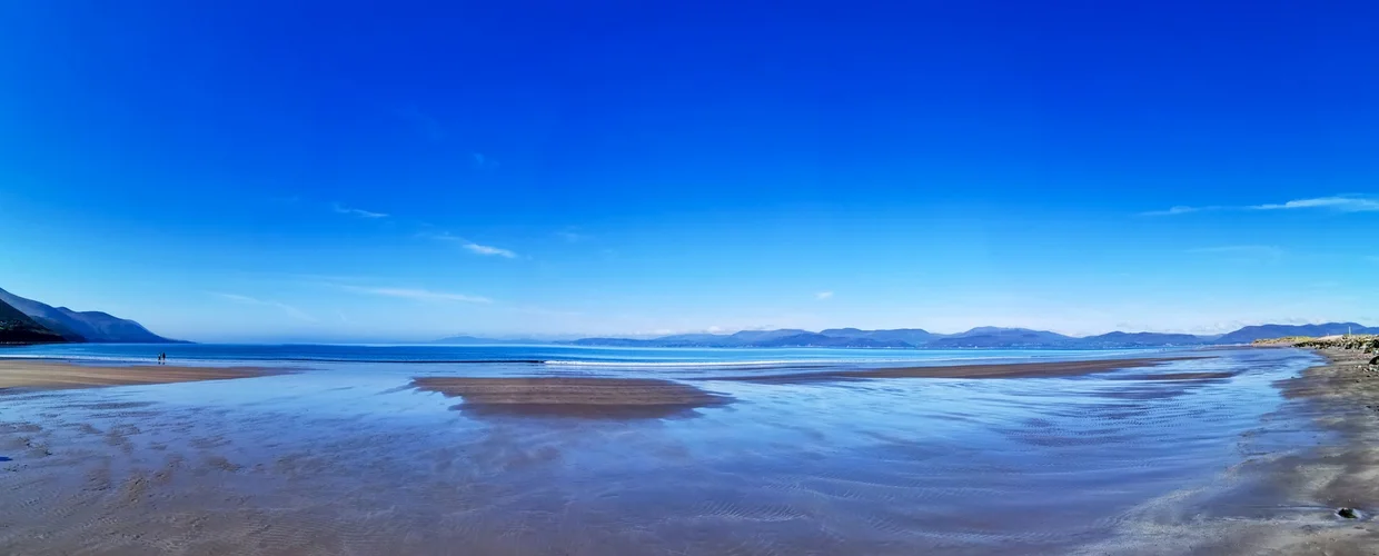 A wide low-tide beach panorama on the Ring of Kerry with rippled sand and distant mountains