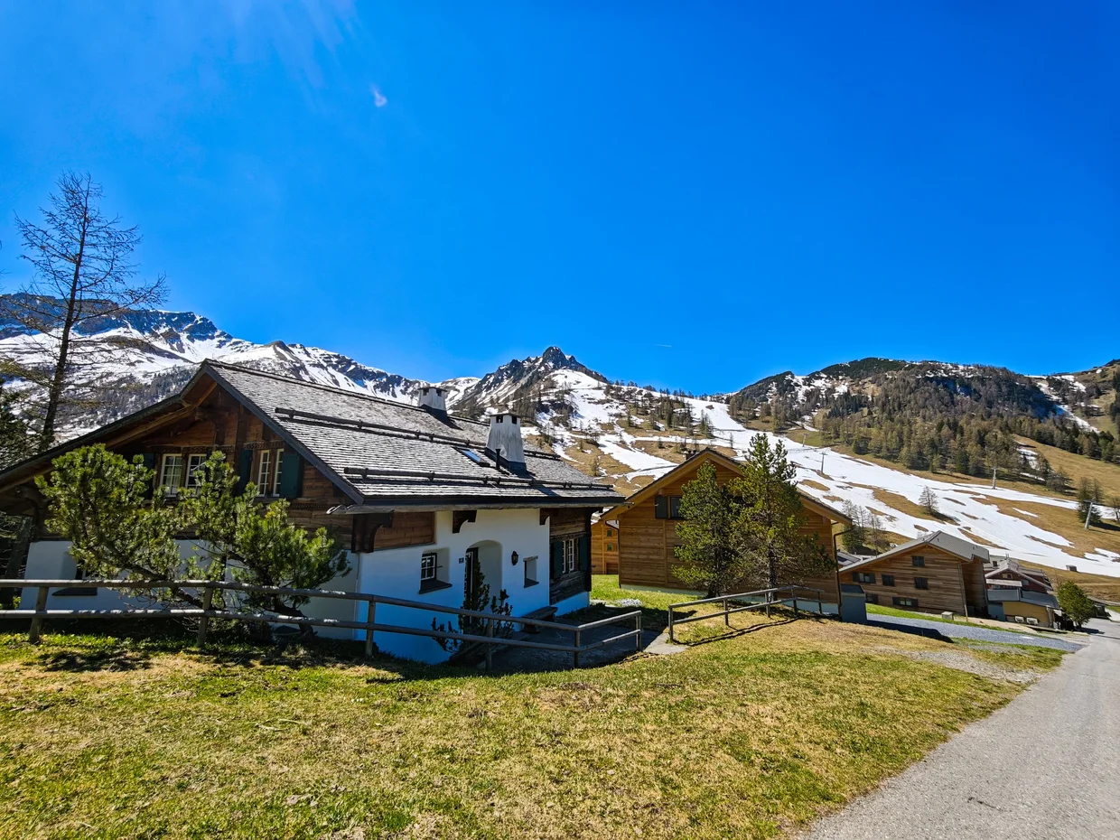 Wooden chalet with a snow-capped peak directly behind