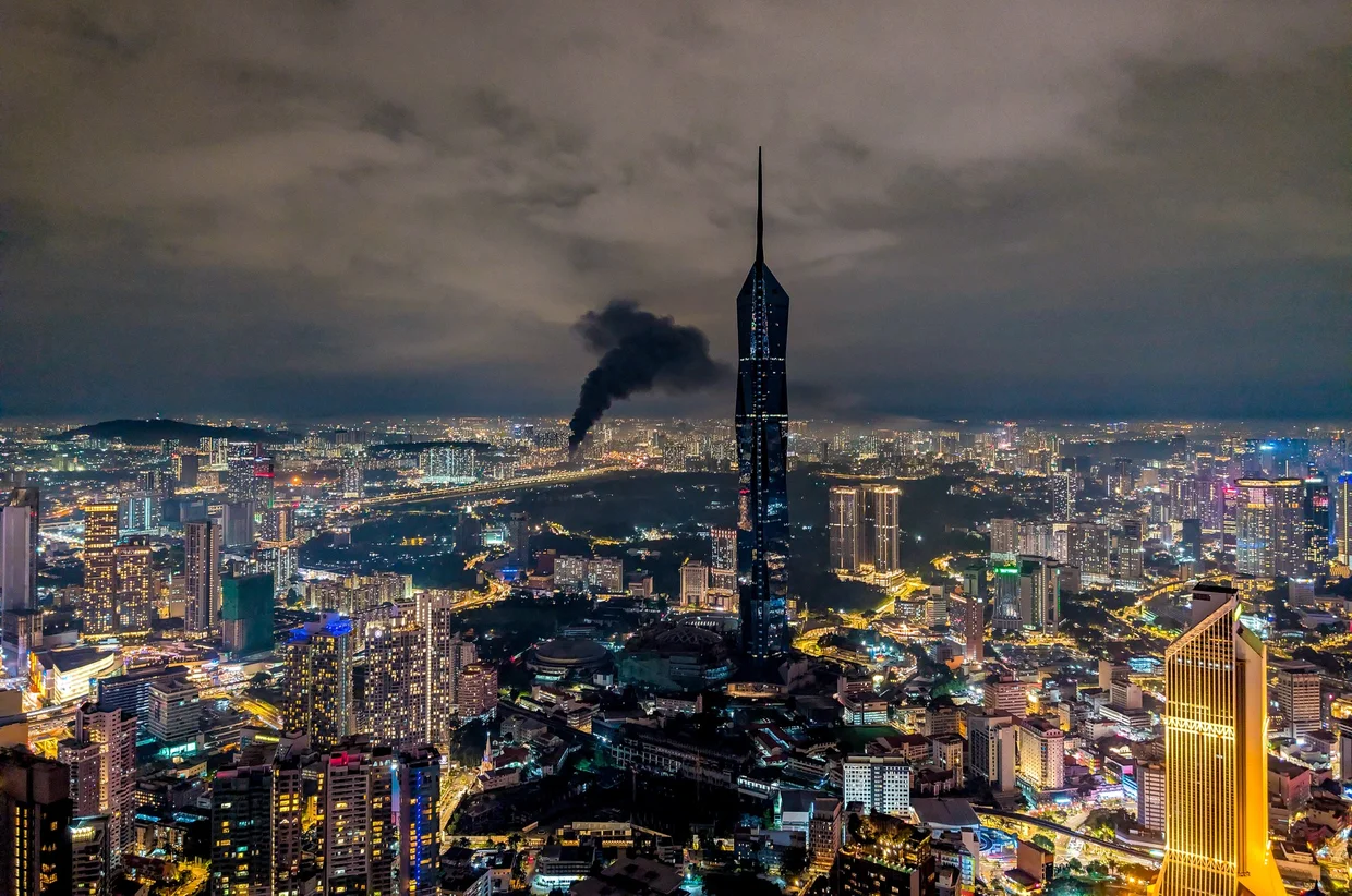 Merdeka 118 at night, with the smoke effect at the spire