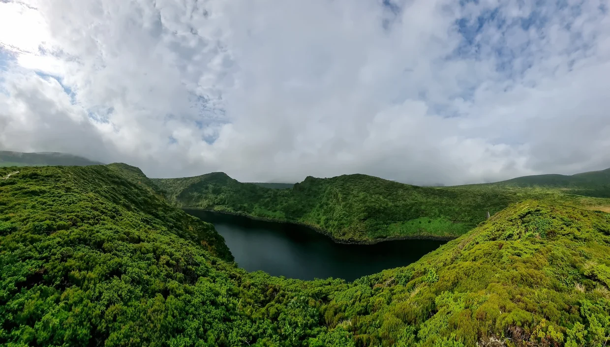 Volcanic crater lake surrounded by lush green vegetation in the Azores