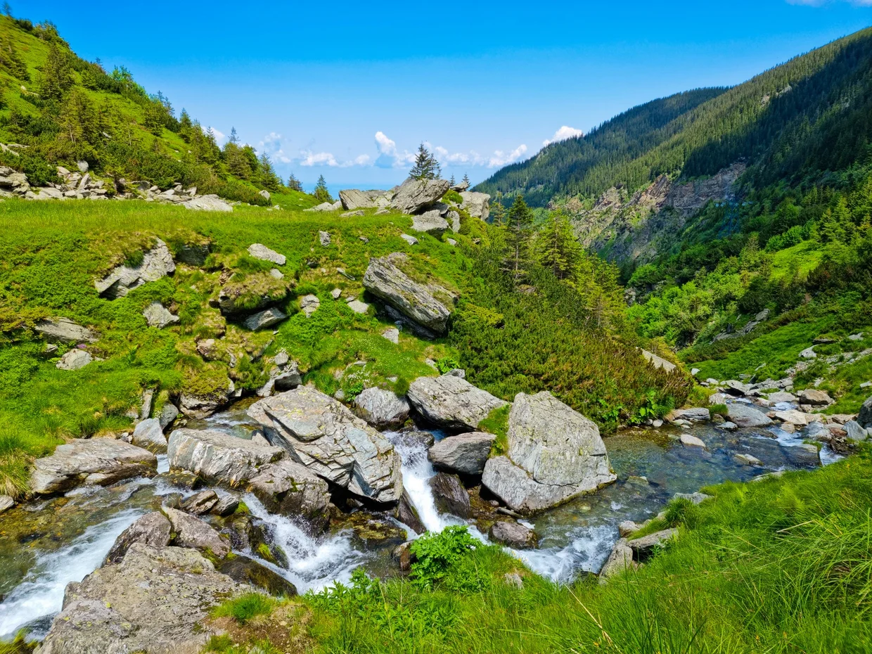 Stream and rocks below the high mountain slopes