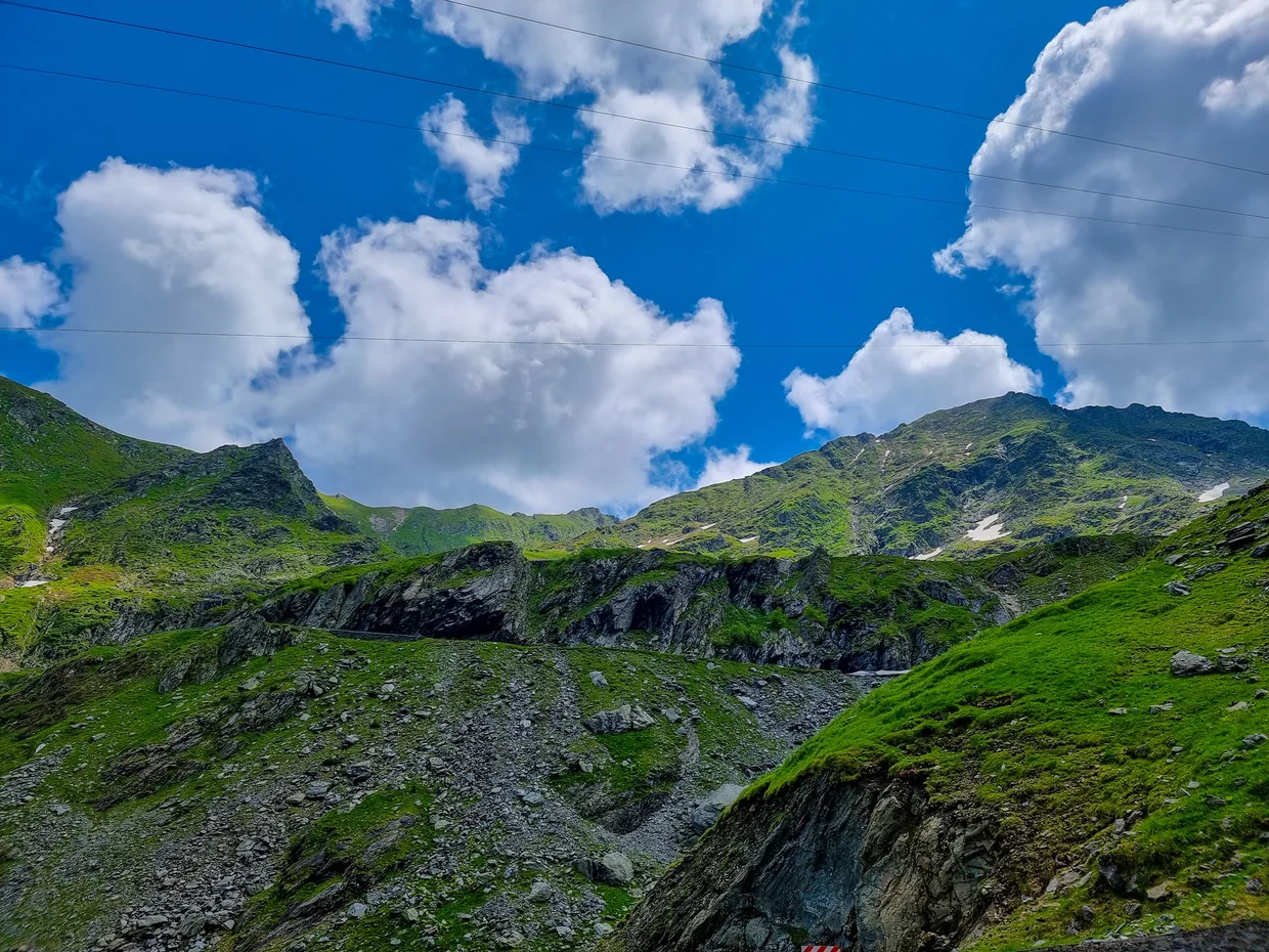 A sweeping green valley under a big mountain sky