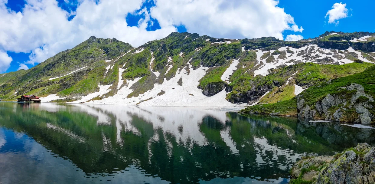 Bâlea Lake with snow patches above the water