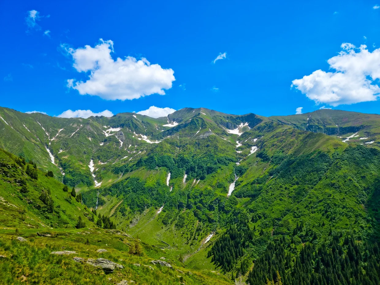 The road threading across the green mountain slopes