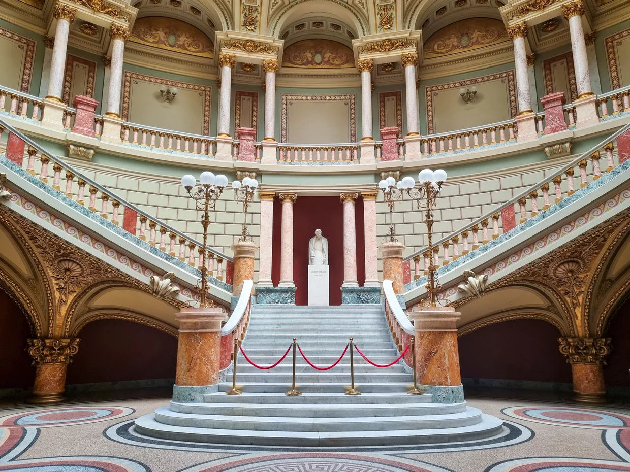 The red-carpeted staircase and gilded interior