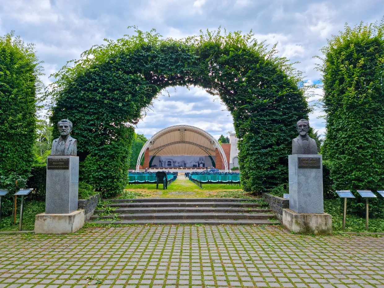 Leafy arch framing an open-air stage in the park