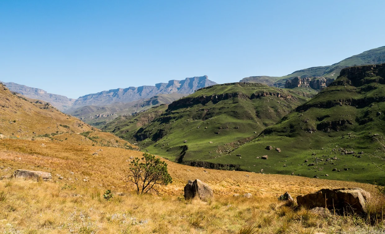Drakensberg peaks with green grassy slopes in the foreground