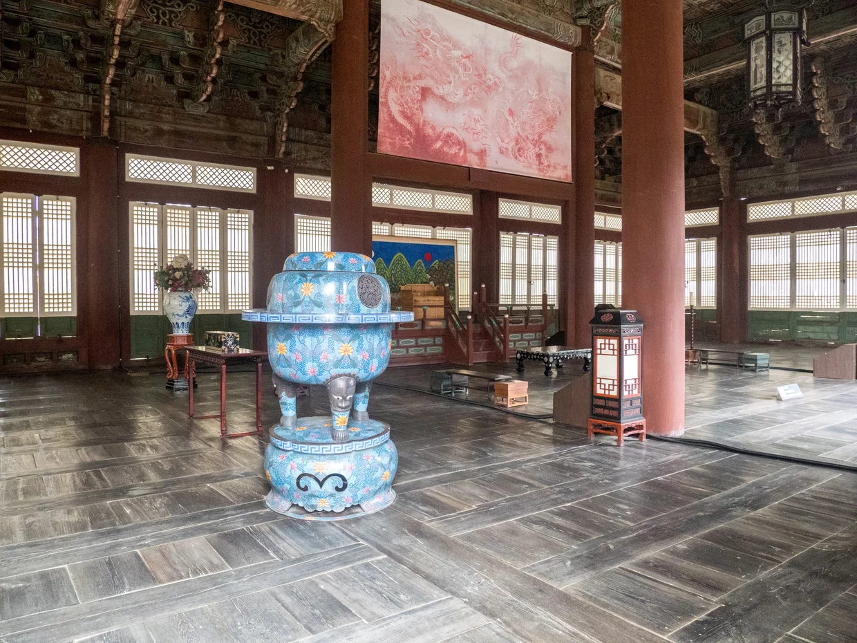 Palace interior with ornate blue ceramic vessel and painted ceiling