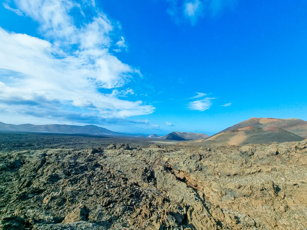 Wide panorama of lava fields with volcanic cones on the horizon
