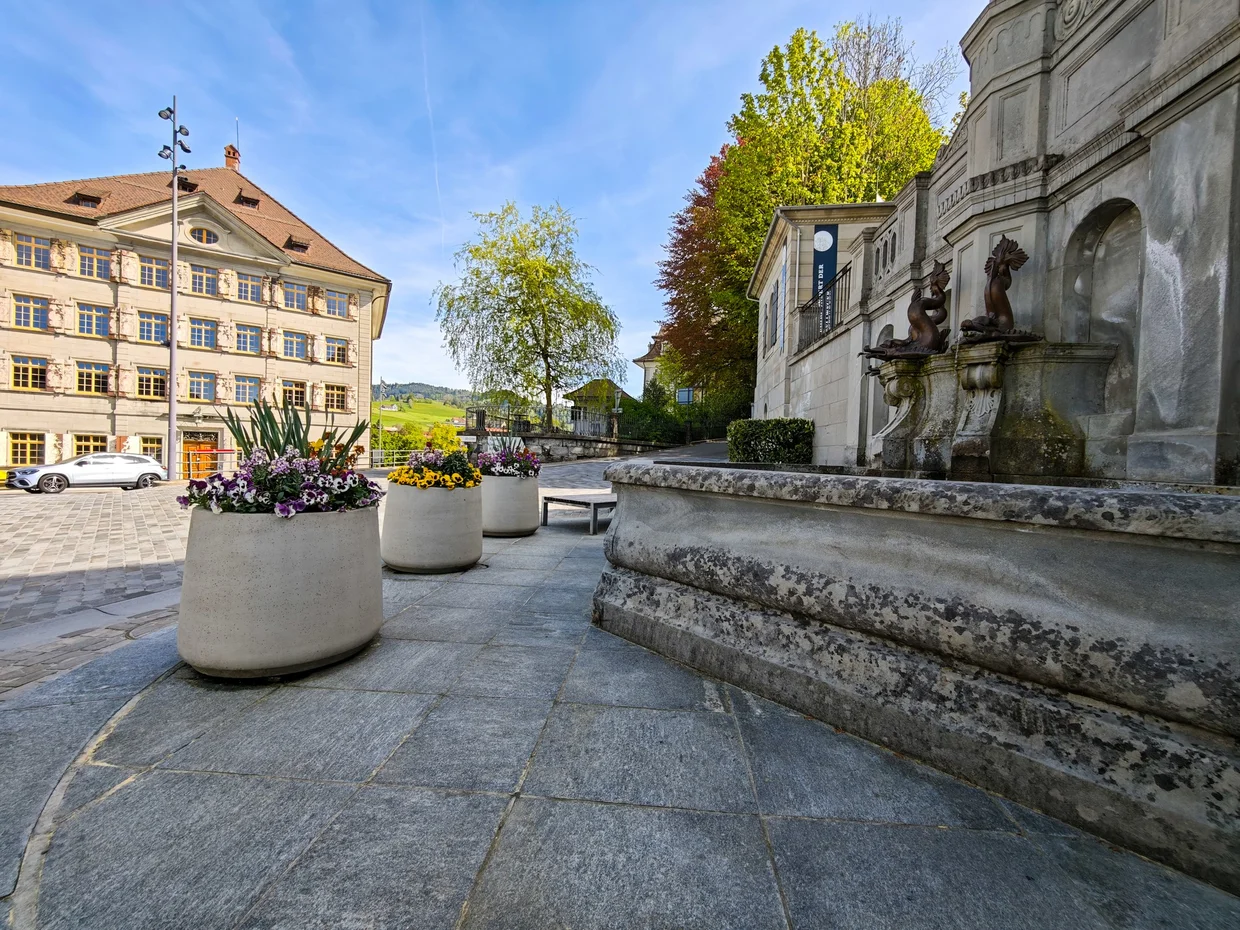 Cobblestone foreground with planters in front of a merchant mansion