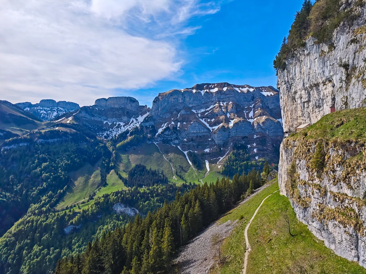 Cliff path narrowing along the limestone wall, valley below