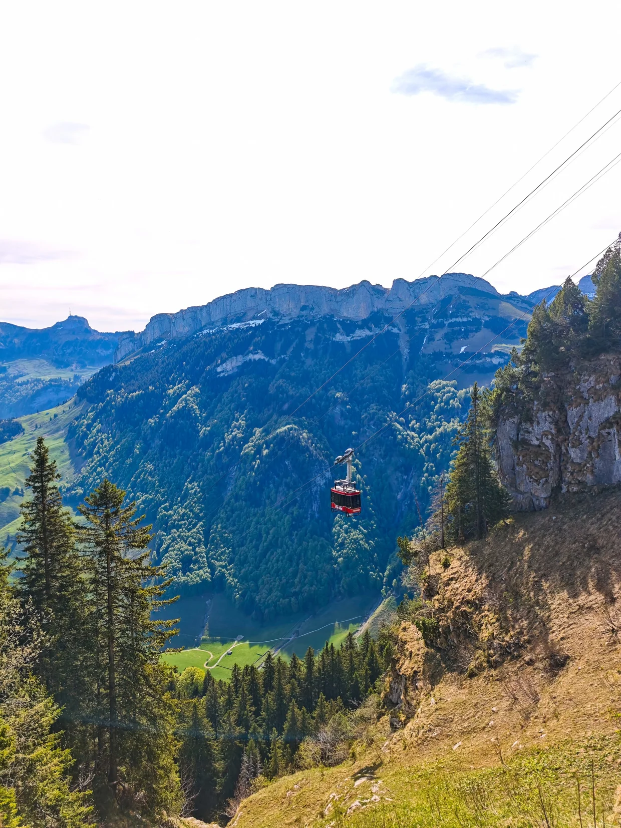 Red Wasserauen-Ebenalp cable car coming up against limestone cliffs