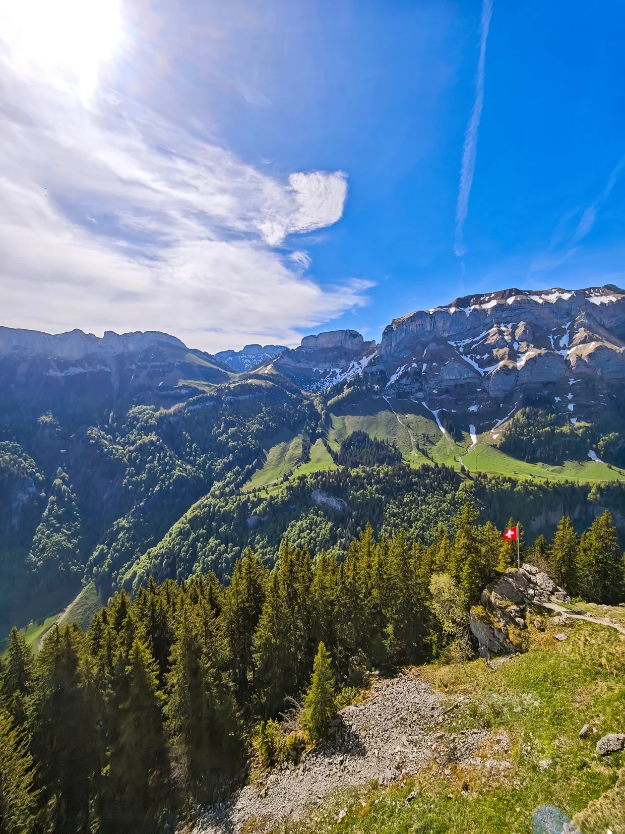 Swiss flag perched on a rocky outcrop just below Ebenalp's summit