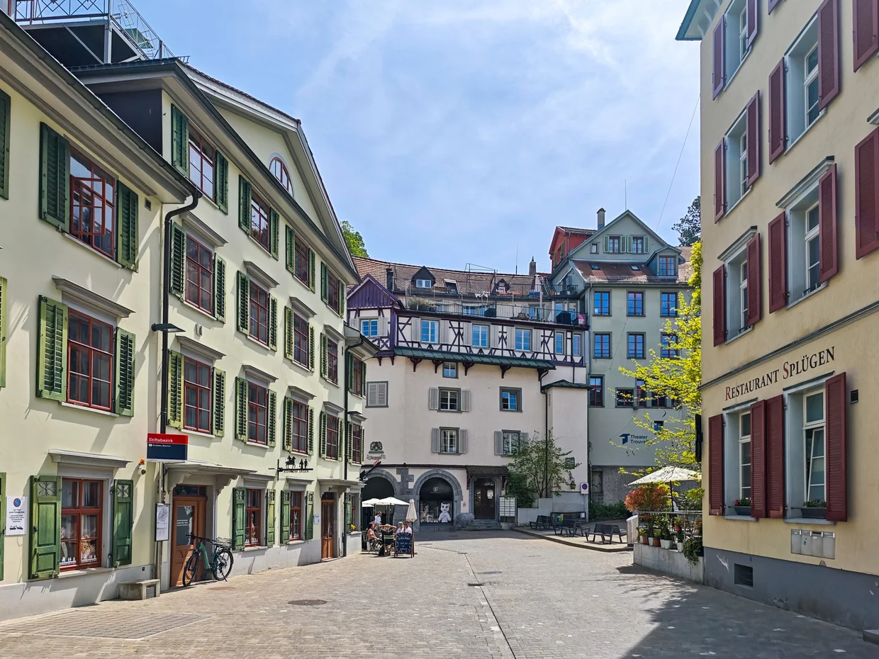 Quiet square with green shutters and Restaurant Splügen