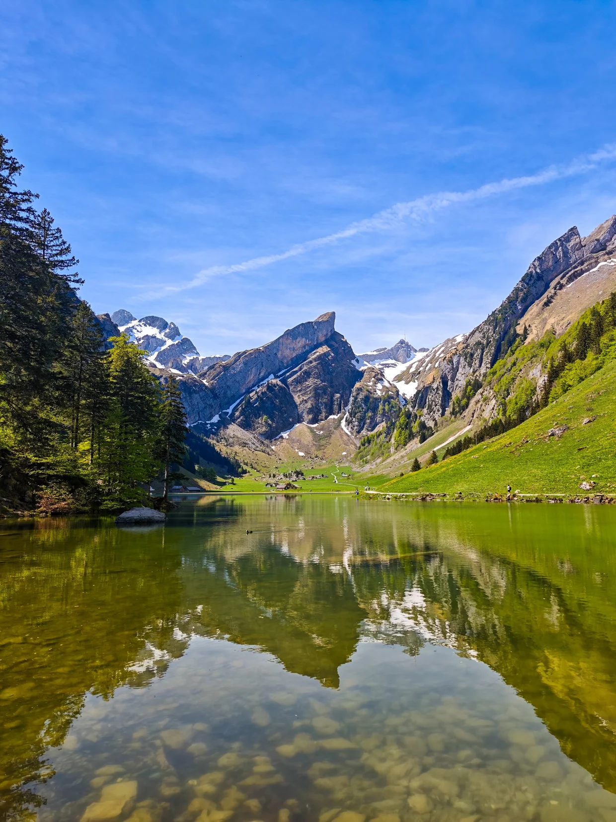 Seealpsee in clear morning light, the Säntis ridge mirrored over a stony shallow bed