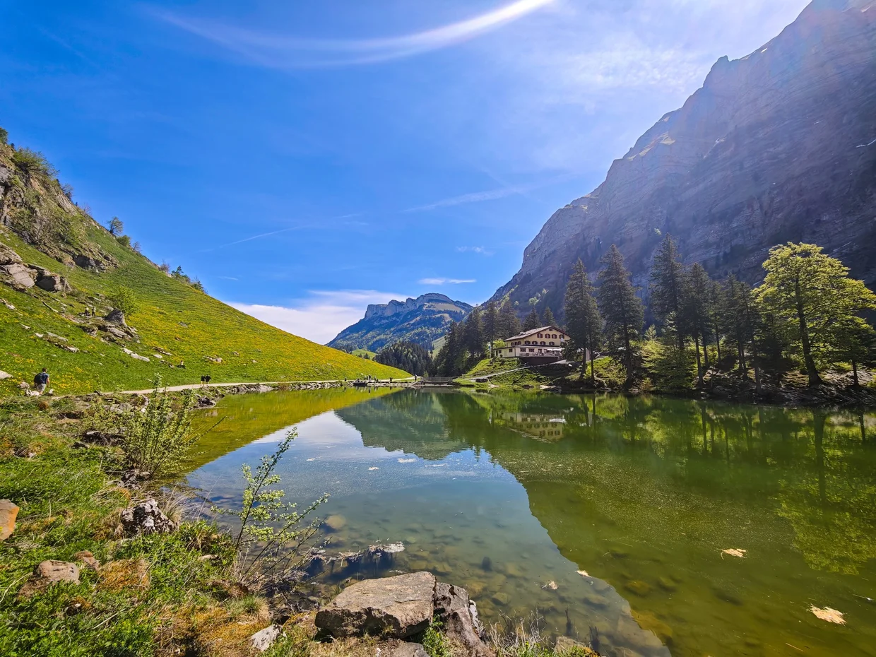 The lakeside guesthouse and terrace mirrored at the far end of Seealpsee