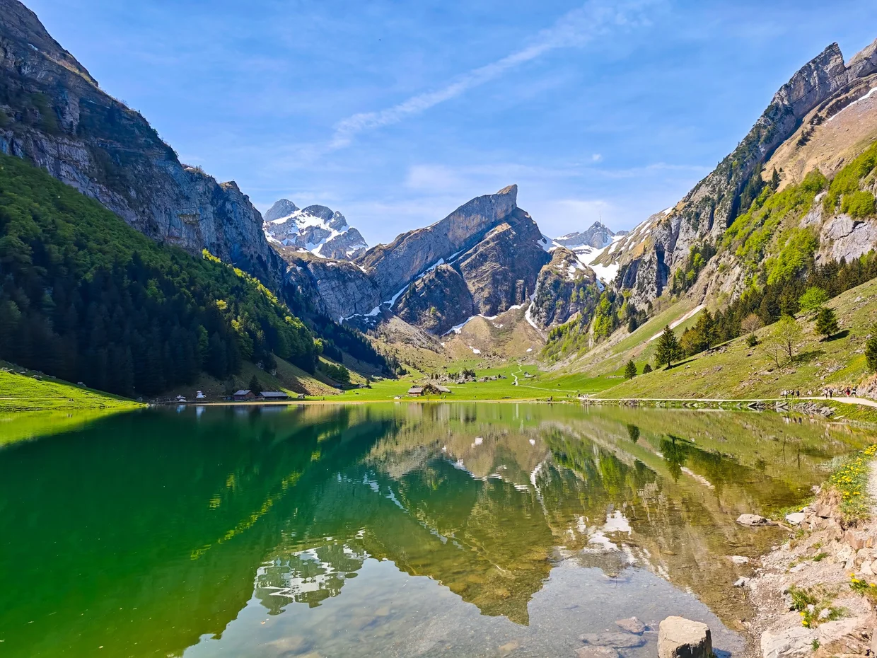 Seealpsee with the Säntis peaks reflected in glassy green water