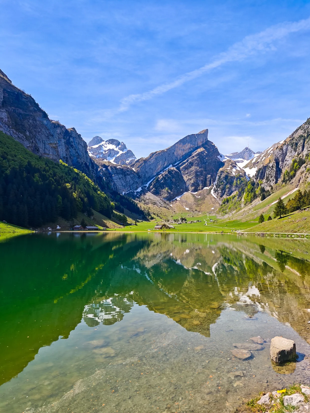 The green-blue lake with a single rock breaking the surface in the foreground