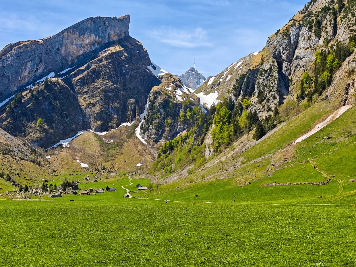 The Alpstein massif you're riding up into, peaks straight out of green pasture